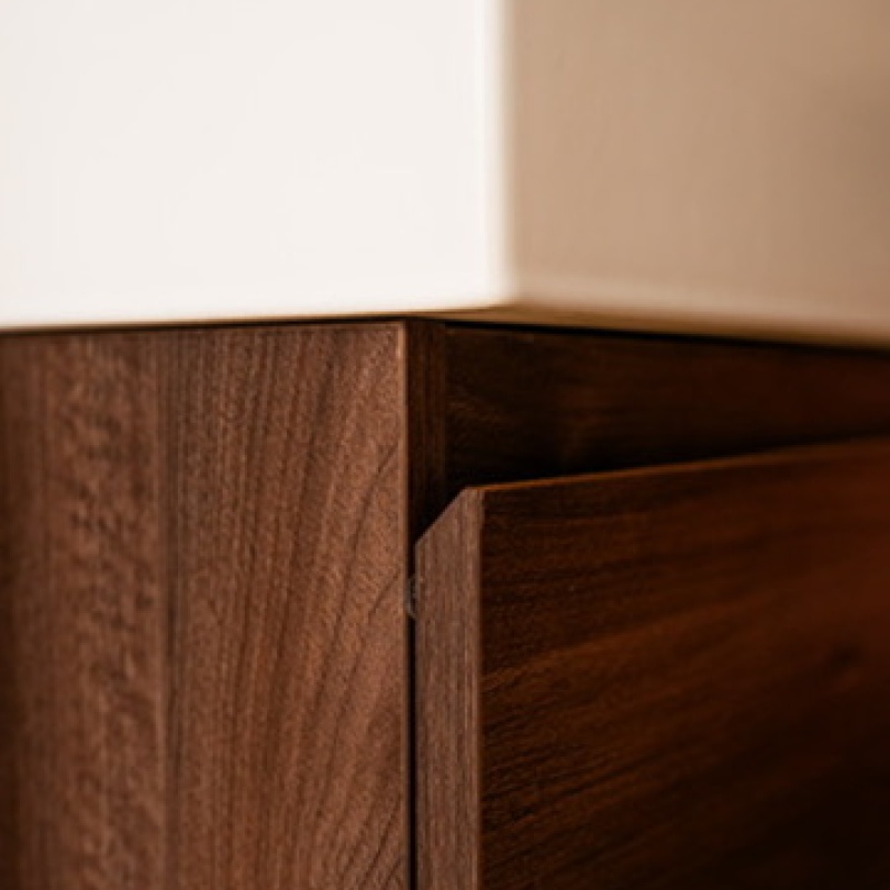 Detail of a white basin on a walnut vanity unit