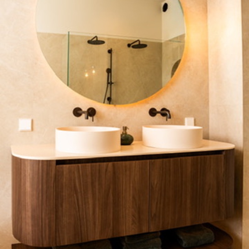 Double washbasin with a round mirror and a walnut vanity unit in the main bathroom