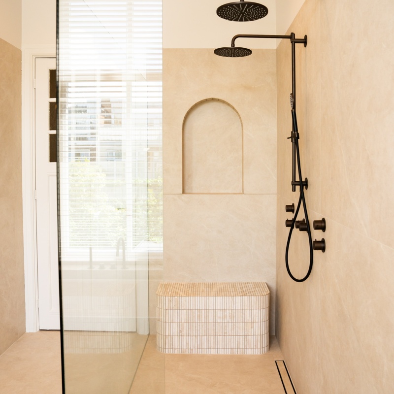 Overview of the walk-in shower in the main bathroom with a double black rain shower