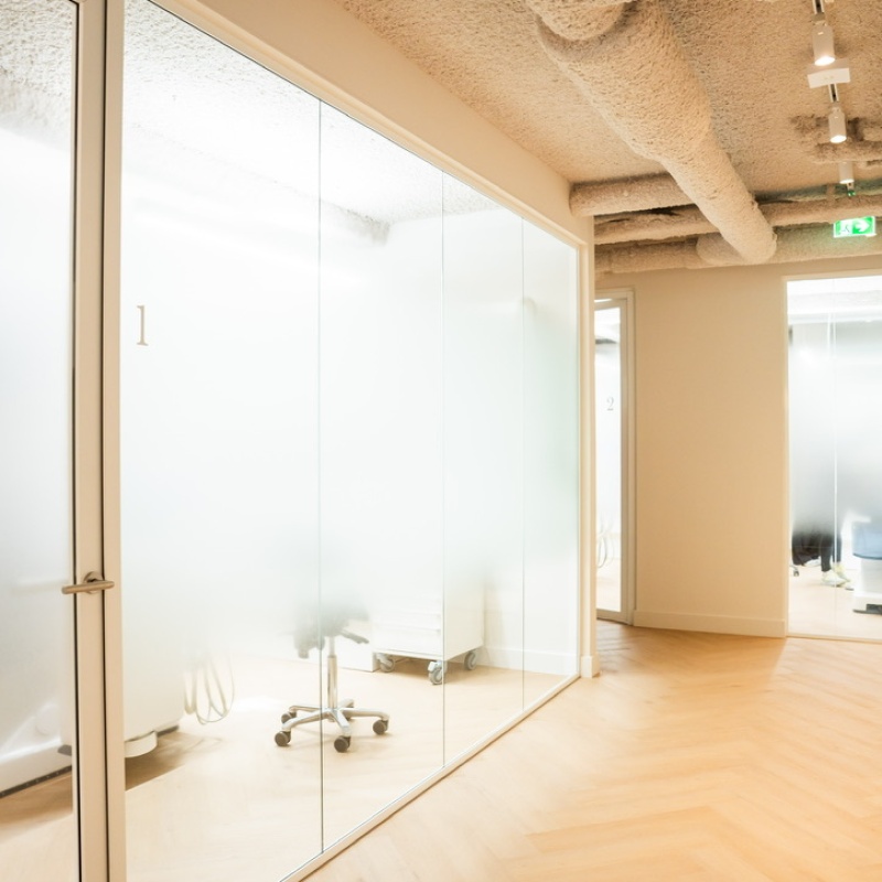 Behandelkamer 1 achter een glazen wand met spuitbeton plafond