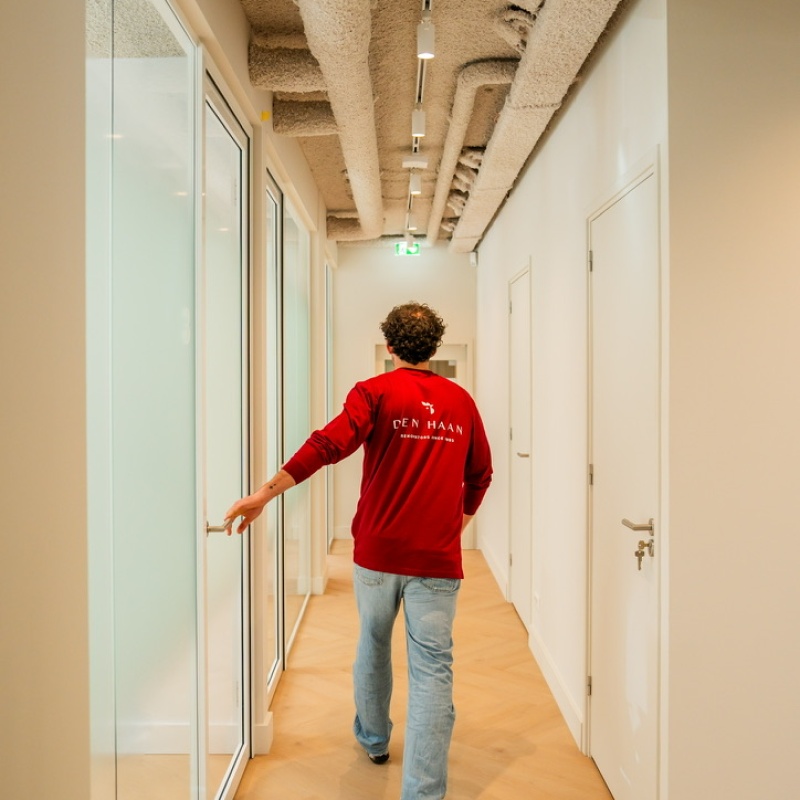 Medewerker van Den Haan Renovators in de gang van de tandartspraktijk