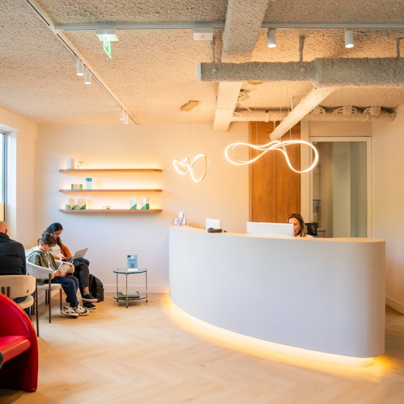Receptie en wachtruimte met gebogen balie en sfeerverlichting