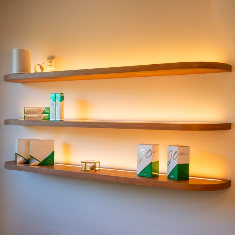 Verlichte houten wandplanken met verzorgingsproducten in de tandartspraktijk